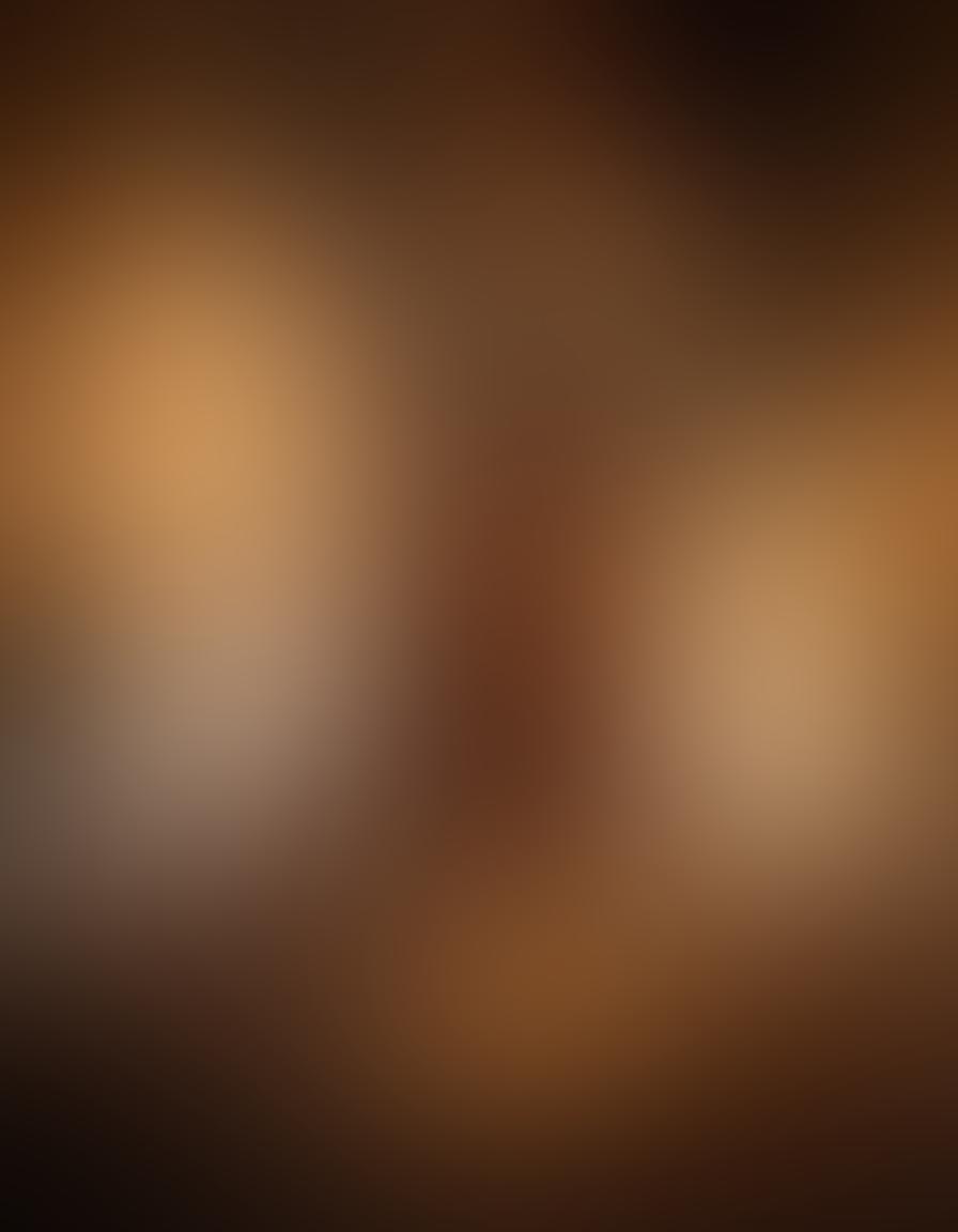 A beautifully intimate scene depicting a couple in a softly lit bedroom, exploring sensuality and connection. Include elegant textures and warm colors to enhance feelings of safety and desire. Visual elements like candles and plush fabrics should create a cozy atmosphere, inviting the viewer to delve into first-time experiences. The couple's expressions should reflect curiosity and enjoyment, promoting a sense of adventure in intimacy. soft-focus. warm tones. intimate setting.